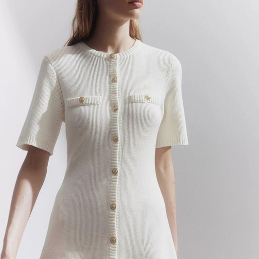 White ribbed dress with short sleeves and buttons on a plain background